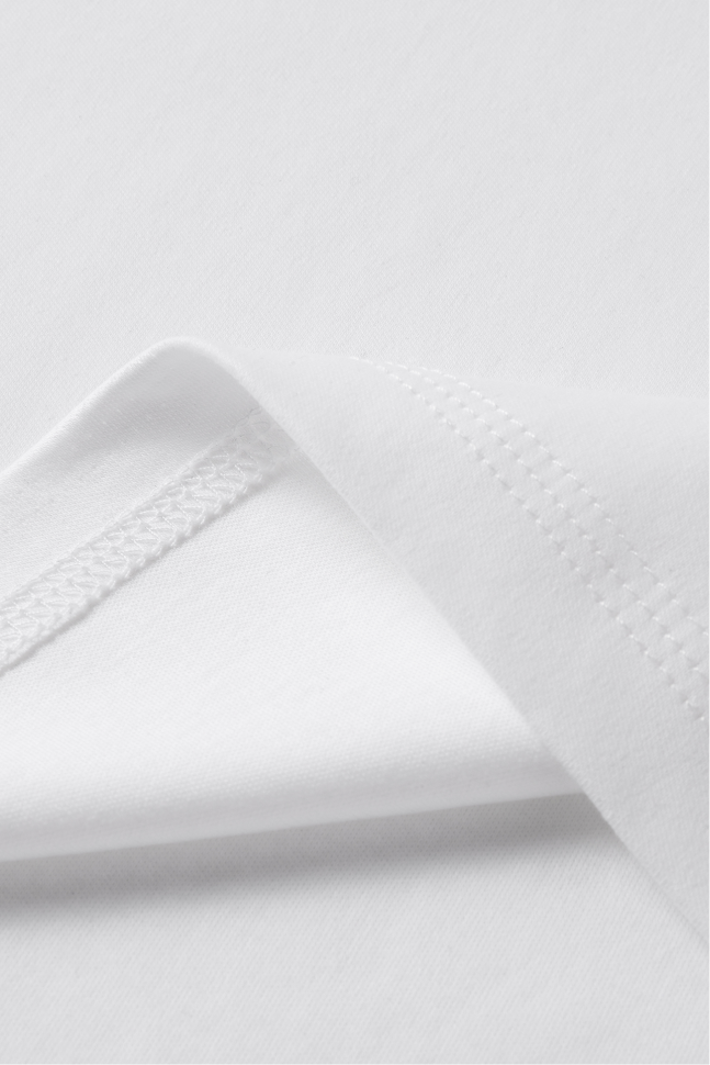 Close-up of the white T-shirt hem with double-stitched finishing.