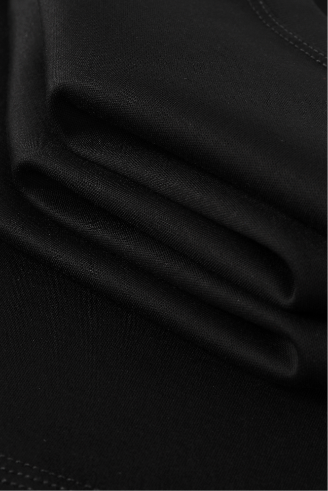 A close-up of folded black fabric with visible weave texture and subtle stitching along the edges.