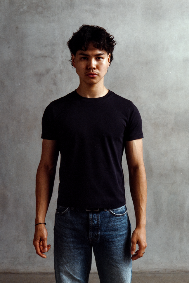 Model wearing a black crewneck short-sleeve T-shirt with blue jeans.