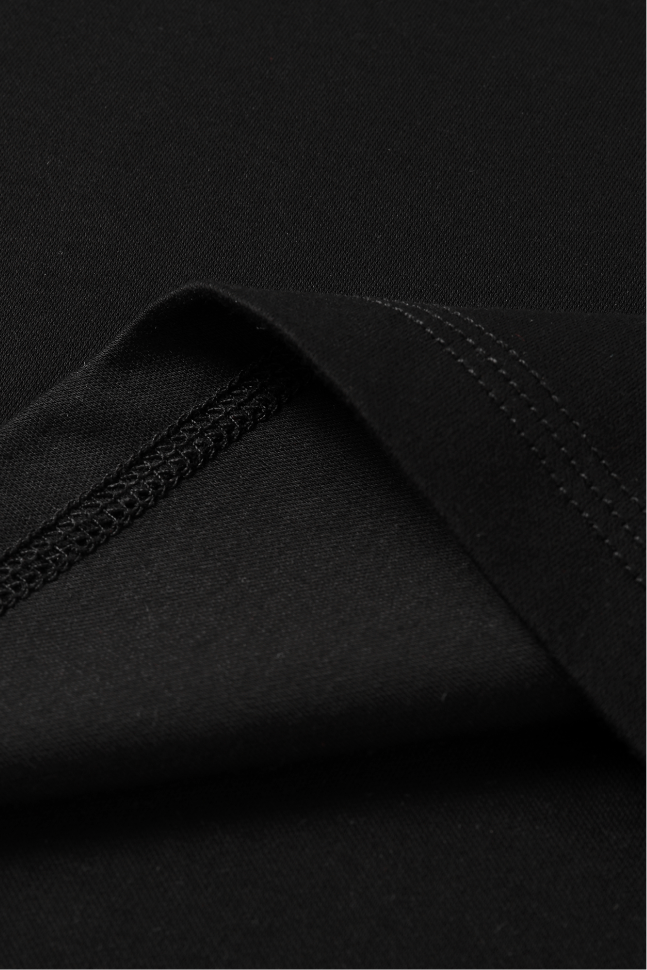 Close-up of a black fabric showing a folded corner with fine stitching.