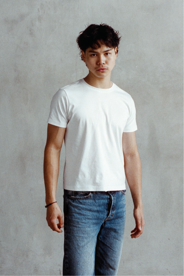 Model wearing a white crew neck T-shirt with blue jeans.